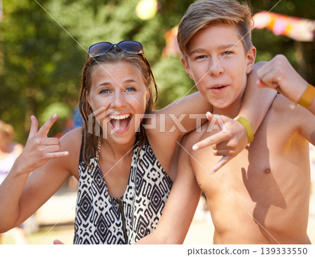 Crazy, teenager and portrait of friends in park at music festival with rock n roll sign in summer. Hands, girl and boy in hug with freedom on vacation, holiday or smile for concert adventure in woods Crazy, teenager and portrait of friends in park at music festival with rock n roll sign in summer. Hands, girl and boy in hug with freedom on vacation, holiday or smile for concert adventure in woods 139333550