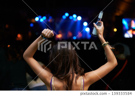 Woman, back and dancing at night festival, party or music concert for DJ, performance or sound. Rear view of female person enjoying late evening entertainment at outdoor carnival, rave or audio event Woman, back and dancing at night festival, party or music concert for DJ, performance or sound. Rear view of female person enjoying late evening entertainment at outdoor carnival, rave or audio event 139333584