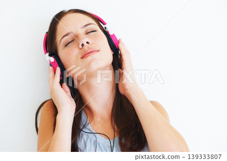 Woman, peace and listening to music on headphones to relax with sound in white background of studio. Radio, podcast or person streaming a jazz, album or hear audio of song playing with technology Woman, peace and listening to music on headphones to relax with sound in white background of studio. Radio, podcast or person streaming a jazz, album or hear audio of song playing with technology 139333807