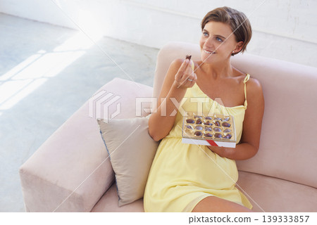 Pregnant woman, eating chocolate and relax in home, alone and happiness for delicious pregnancy craving. Good mood, comfort food and candy dessert for maternity, snack and sweet tooth satisfaction Pregnant woman, eating chocolate and relax in home, alone and happiness for delicious pregnancy craving. Good mood, comfort food and candy dessert for maternity, snack and sweet tooth satisfaction 139333857