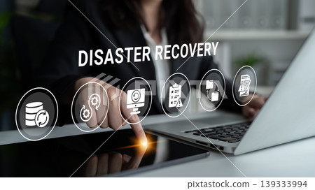 Professional Businesswoman Engaging with Disaster Recovery Software on Touchscreen Laptop in Modern Office Setting with Digital Icons Ledger Professional Businesswoman Engaging with Disaster Recovery Software on Touchscreen Laptop in Modern Office Setting with Digital Icons Ledger 139333994