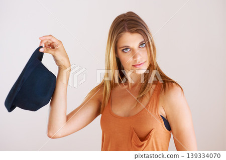 Portrait, fashion and serious woman with hat in studio for style, clothing or choice on white background. Hand holding, bowler and face of female model with gesture, decision or fashionable outfit 139334070