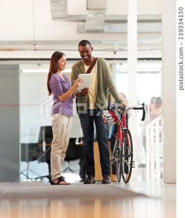 People, talking and tablet in office with bicycle for travel or morning commute to workplace. Bike messenger, logistics and discussion of business, project or checklist with employees and client 139334150