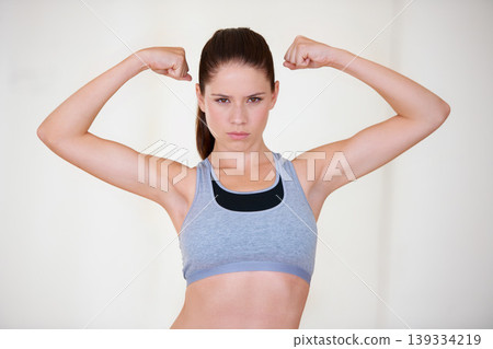 Woman, portrait or serious in studio with flex for fitness, wellness or workout strength with sportswear. Person, athlete or pride for biceps, exercise or training on white background or mockup space Woman, portrait or serious in studio with flex for fitness, wellness or workout strength with sportswear. Person, athlete or pride for biceps, exercise or training on white background or mockup space 139334219