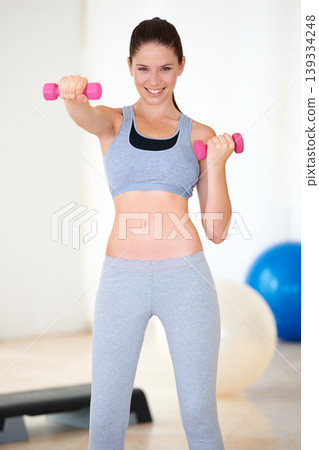 Woman, arm exercise or portrait with dumbbells in studio, wellness or fitness for weight loss with confident. Young person, happy and face with workout for muscle training and healthy body in gym Woman, arm exercise or portrait with dumbbells in studio, wellness or fitness for weight loss with confident. Young person, happy and face with workout for muscle training and healthy body in gym 139334248