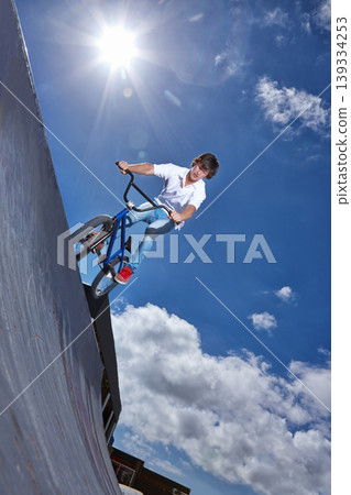 Ride, bike and teen on ramp for sport performance, jump or training for event at park with blue sky mockup. Bicycle, stunt or kid balance on edge of board in trick for cycling competition challenge Ride, bike and teen on ramp for sport performance, jump or training for event at park with blue sky mockup. Bicycle, stunt or kid balance on edge of board in trick for cycling competition challenge 139334253