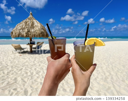 Cheers with Tropical Cocktails on Sunny Aruba Beach Cheers with Tropical Cocktails on Sunny Aruba Beach 139334258