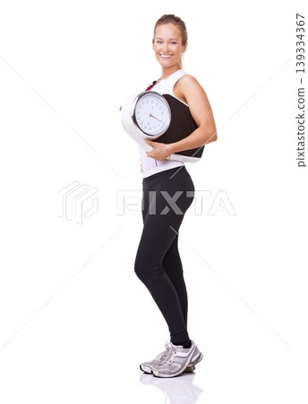 Fitness, scale and portrait of woman with smile, workout and wellness with healthy pride in studio. Health, exercise and body of happy girl with weight loss measurement isolated on white background. Fitness, scale and portrait of woman with smile, workout and wellness with healthy pride in studio. Health, exercise and body of happy girl with weight loss measurement isolated on white background. 139334367