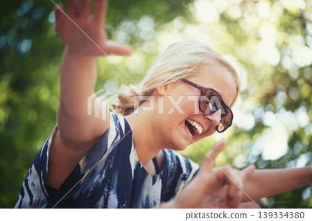 Nature, dance or happy woman in music festival on holiday vacation to relax with smile in park. Shoulders, sunglasses or excited girl with freedom or youth culture for a fun party celebration event Nature, dance or happy woman in music festival on holiday vacation to relax with smile in park. Shoulders, sunglasses or excited girl with freedom or youth culture for a fun party celebration event 139334380