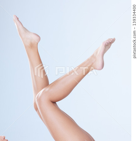 Body care, woman and legs in studio for hair removal, epilation and cosmetology for wellness and laser. Person, depilation and shaving routine for cosmetic, skincare and waxing on blue background Body care, woman and legs in studio for hair removal, epilation and cosmetology for wellness and laser. Person, depilation and shaving routine for cosmetic, skincare and waxing on blue background 139334400