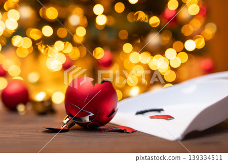 Broken christmas ball decoration on the floor. Cleaning floor from broken ball decoration with scoop and broom Broken christmas ball decoration on the floor. Cleaning floor from broken ball decoration with scoop and broom 139334511