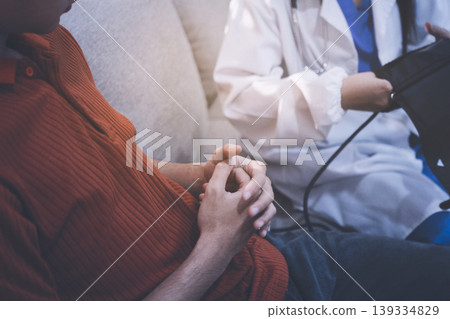 Doctor checks patient's blood pressure with cuff and stethoscope in a medical 139334829