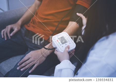 Doctor checks patient's blood pressure with cuff and stethoscope in a medical Doctor checks patient's blood pressure with cuff and stethoscope in a medical 139334831