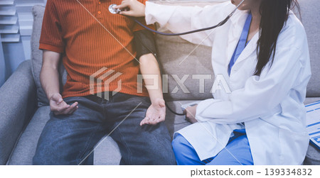 Doctor checks patient's blood pressure with cuff and stethoscope in a medical Doctor checks patient's blood pressure with cuff and stethoscope in a medical 139334832