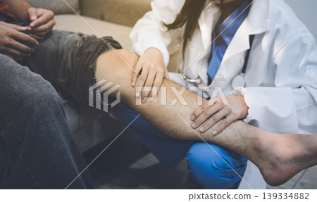 Female doctor examining male patient leg in hospital Female doctor examining male patient leg in hospital 139334882