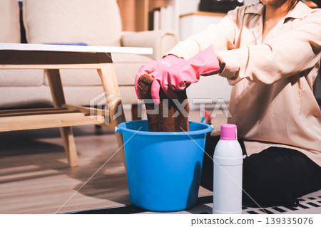 Person cleaning the room, cleaning staff is using cloth and spraying disinfectant to wipe the tables in the company office room. Cleaning staff. Maintaining cleanliness in the organization. Person cleaning the room, cleaning staff is using cloth and spraying disinfectant to wipe the tables in the company office room. Cleaning staff. Maintaining cleanliness in the organization. 139335076