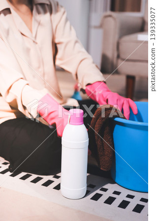 Person cleaning the room, cleaning staff is using cloth and spraying disinfectant to wipe the tables in the company office room. Cleaning staff. Maintaining cleanliness in the organization. Person cleaning the room, cleaning staff is using cloth and spraying disinfectant to wipe the tables in the company office room. Cleaning staff. Maintaining cleanliness in the organization. 139335077