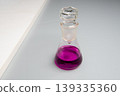 glass flask with pink liquid on gray background. 139335360