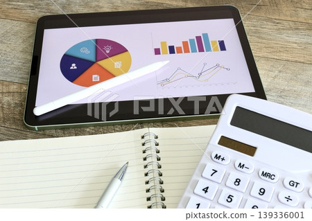 Image of a business desk performing data analysis using graphs on a tablet. Image of a business desk performing data analysis using graphs on a tablet. 139336001