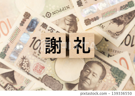 一塊寫著「感恩」字樣的磚塊和許多10,000日元的鈔票。 一塊寫著「感恩」字樣的磚塊和許多10,000日元的鈔票。 139336550