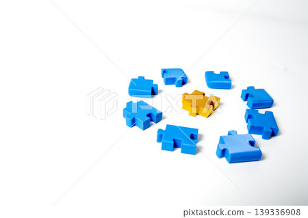 A golden puzzle piece placed in the center of several blue puzzle pieces arranged in a circle on a clean white background. Concept for business leadership, uniqueness, and finding the best solution. A golden puzzle piece placed in the center of several blue puzzle pieces arranged in a circle on a clean white background. Concept for business leadership, uniqueness, and finding the best solution. 139336908