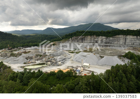 Aerial view of open pit mining site of limestone materials extraction for construction industry Aerial view of open pit mining site of limestone materials extraction for construction industry 139337583