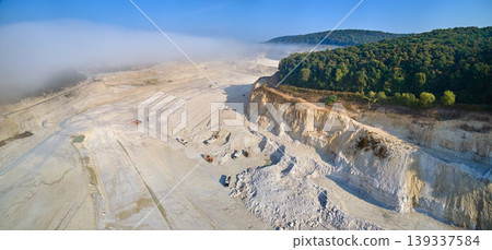 Aerial view of open pit mining of limestone materials for construction industry with excavators and dump trucks. 139337584