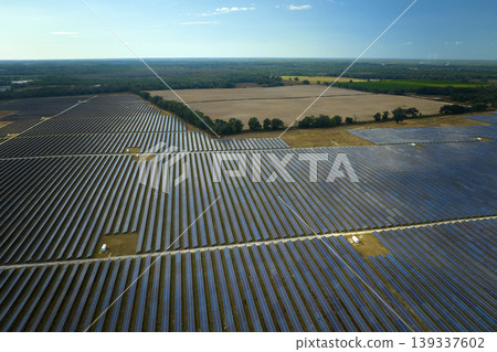 Aerial view of large sustainable electrical power plant with rows of solar photovoltaic panels for producing clean electric energy. Concept of renewable electricity with zero emission Aerial view of large sustainable electrical power plant with rows of solar photovoltaic panels for producing clean electric energy. Concept of renewable electricity with zero emission 139337602