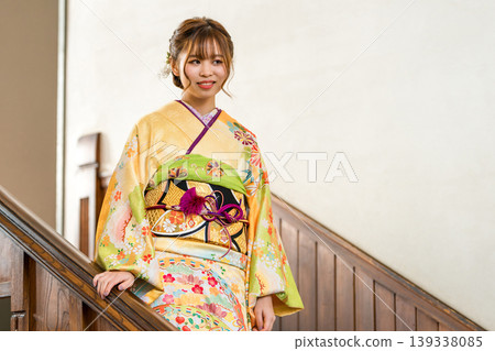 一位穿著振袖和服的女子走下復古西式豪宅的樓梯。 一位穿著振袖和服的女子走下復古西式豪宅的樓梯。 139338085