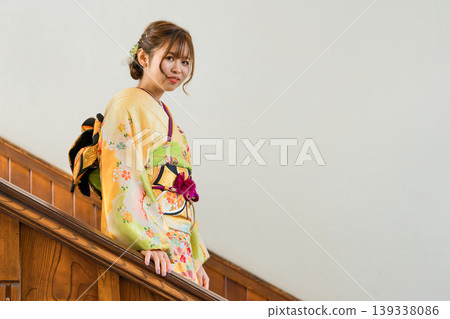 一位穿著振袖和服的女子走下復古西式豪宅的樓梯。 一位穿著振袖和服的女子走下復古西式豪宅的樓梯。 139338086