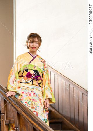 一位穿著振袖和服的女子走下復古西式豪宅的樓梯。 一位穿著振袖和服的女子走下復古西式豪宅的樓梯。 139338087