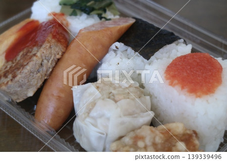 便當盒,內含飯糰和小菜 便當盒,內含飯糰和小菜 139339496