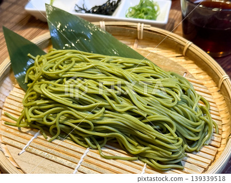 A Japanese set meal featuring soba noodles served with condiments and dipping sauce. 139339518