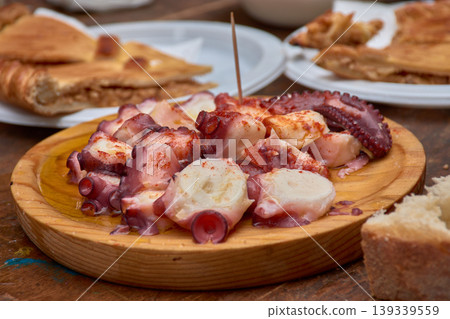 Traditional portion of Galician-style octopus with a wooden toothpick, ready to eat at a local fair Traditional portion of Galician-style octopus with a wooden toothpick, ready to eat at a local fair 139339559