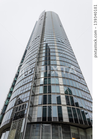 Tall corporate office building towering into an overcast sky Tall corporate office building towering into an overcast sky 139340181