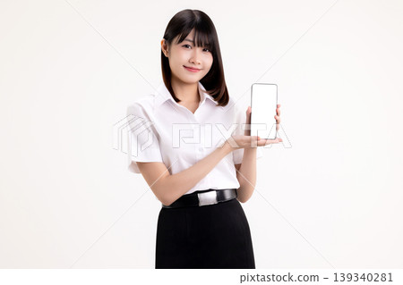 Smiling young Asian woman in student uniform presenting a smartphone with white blank screen. Happy female university student holding mobile phone mockup for app or website display. Smiling young Asian woman in student uniform presenting a smartphone with white blank screen. Happy female university student holding mobile phone mockup for app or website display. 139340281