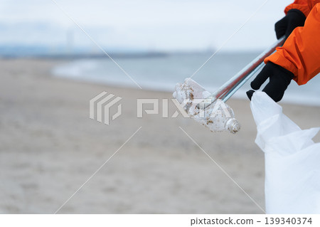 People picking up trash on the beach 139340374