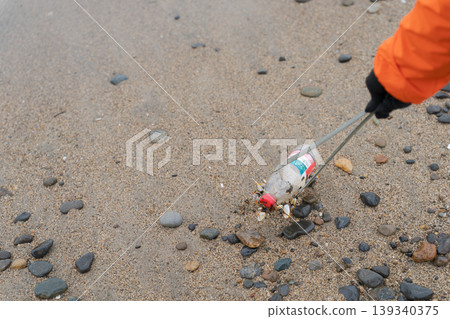 人們在海灘上撿垃圾 人們在海灘上撿垃圾 139340375