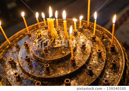 Lit candles symbolizing prayer, faith, and spirituality in orthodox church Lit candles symbolizing prayer, faith, and spirituality in orthodox church 139340380
