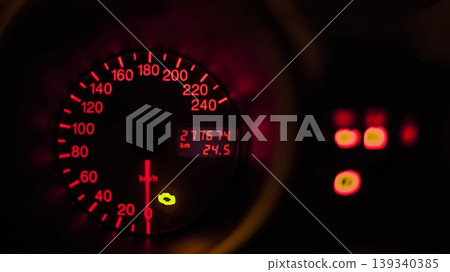 Car speedometer showing kilometers per hour and total kilometers driven at night 139340385