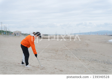 人們在海灘上撿垃圾 人們在海灘上撿垃圾 139340528