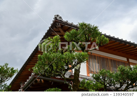 Close-up of the roof of Tenryuji Temple in Kyoto, Japan with trees. Roof tile pattern. Major tourist attraction in Kansai region in Japan. Japan famous historic architecture. Building structure. Close-up of the roof of Tenryuji Temple in Kyoto, Japan with trees. Roof tile pattern. Major tourist attraction in Kansai region in Japan. Japan famous historic architecture. Building structure. 139340597