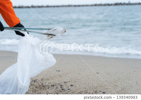 人們在海灘上撿垃圾 人們在海灘上撿垃圾 139340983
