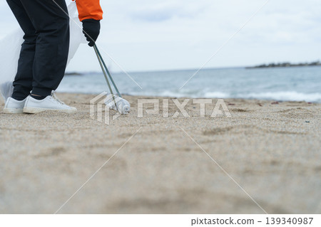 人們在海灘上撿垃圾 人們在海灘上撿垃圾 139340987