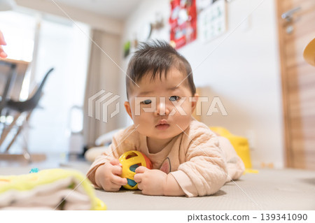 A Japanese baby boy chewing on a toy ball. A Japanese baby boy chewing on a toy ball. 139341090