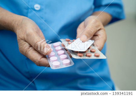 Asian elderly woman holding pill drug in hand, strong healthy medical concept. 139341191