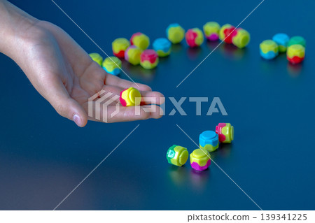 Korean traditional game kit Gonggi. Colourful plastic stones on the hand. 139341225