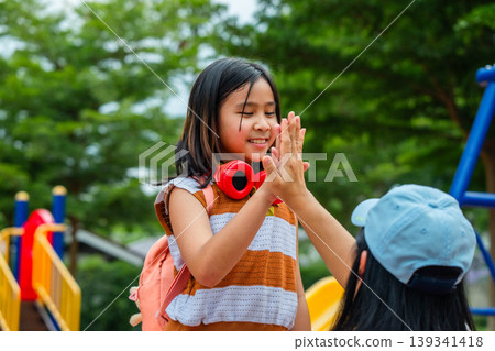 Happy Asian mother saying goodbye and sending her daughter to school, Back to school and family relationship concept. Happy Asian mother saying goodbye and sending her daughter to school, Back to school and family relationship concept. 139341418