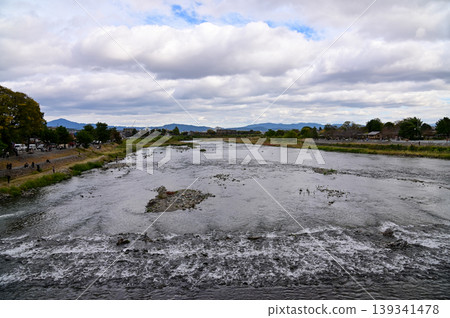 The view of Katsura River at autumn from Togetsukyo Bridge, Kyoto, Japan. A well-known place of scenic beauty in the western hills of Kyoto. Nature and travel concept. The view of Katsura River at autumn from Togetsukyo Bridge, Kyoto, Japan. A well-known place of scenic beauty in the western hills of Kyoto. Nature and travel concept. 139341478