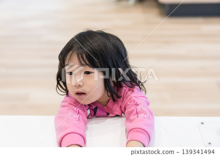 A young Japanese girl playing with exhibits at a science museum. A young Japanese girl playing with exhibits at a science museum. 139341494